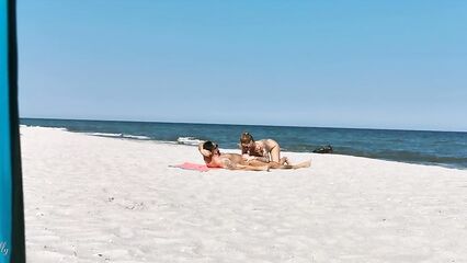 Два парня и девушка устроили групповой секс на нудистском пляже