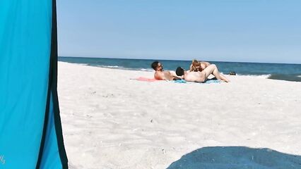 Два парня и девушка устроили групповой секс на нудистском пляже